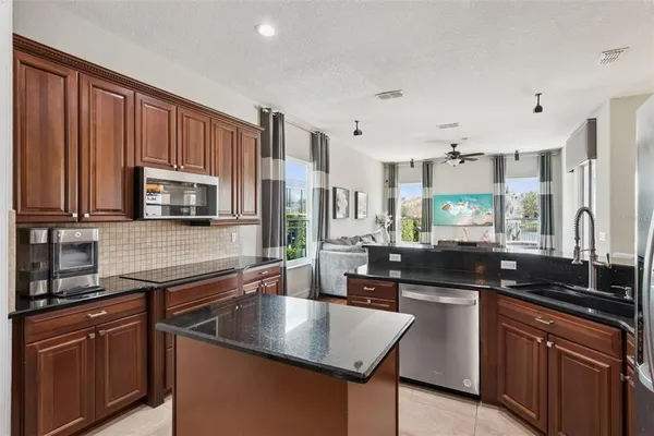 a kitchen with stainless steel appliances granite countertop a sink stove and microwave