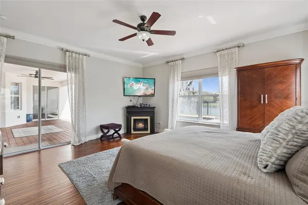 a spacious bedroom with a bed a fireplace and a large window