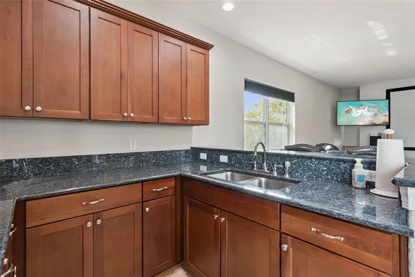 a kitchen with granite countertop stainless steel appliances sink and cabinets