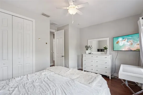 a bedroom with a bed and a chandelier fan
