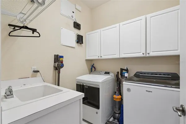 a utility room with sink dryer and washer