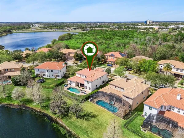 an aerial view of residential houses with outdoor space and lake view