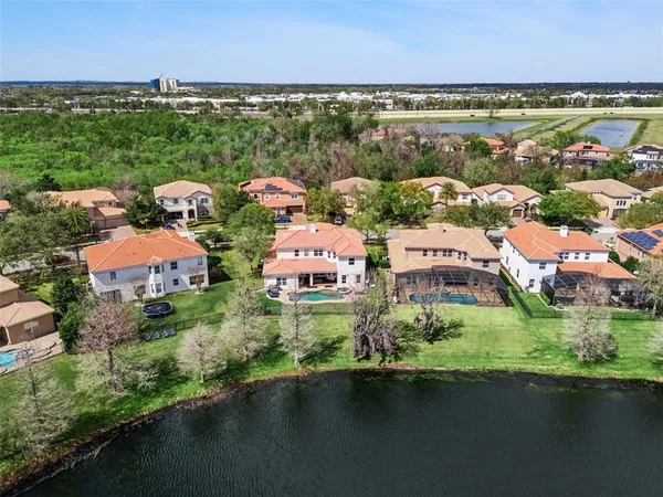 an aerial view of residential houses with outdoor space and lake view