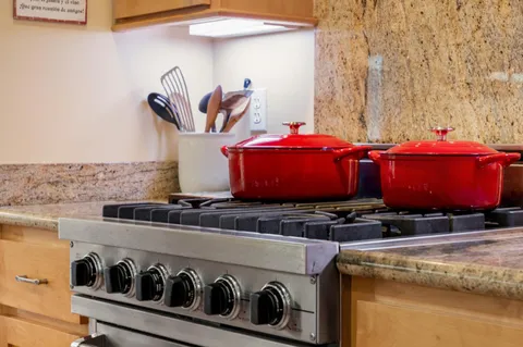 a view of a kitchen with stainless steel appliances granite countertop a stove and a sink