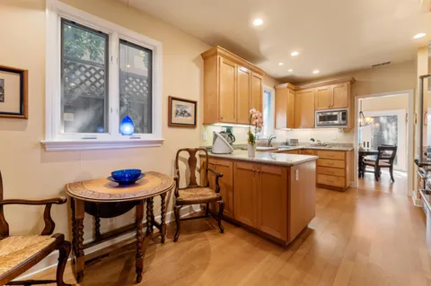 a kitchen with a table chairs a sink dishwasher window and cabinets