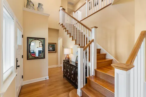 a view of a hallway with wooden floor and staircase
