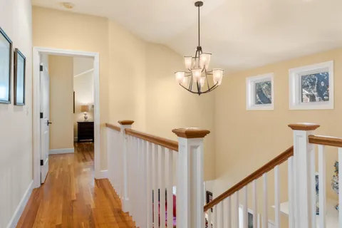 a view of a hallway with wooden floor and staircase