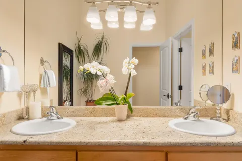 a bathroom with a granite countertop sink and a mirror