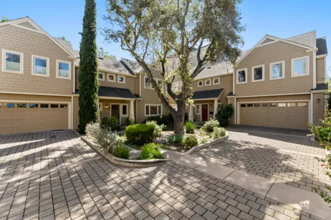 a front view of a house with a yard and potted plants