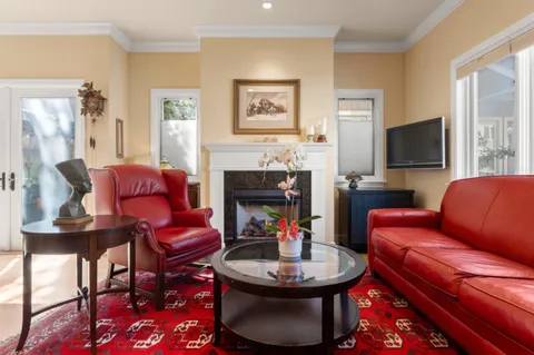a living room with furniture a fireplace and a flat screen tv