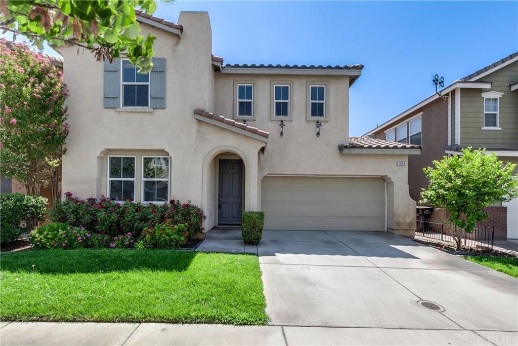 1656 Julia Way Riverside, CA 92501 - Photo 1 of 1 a white house with a small yard plants and a large tree