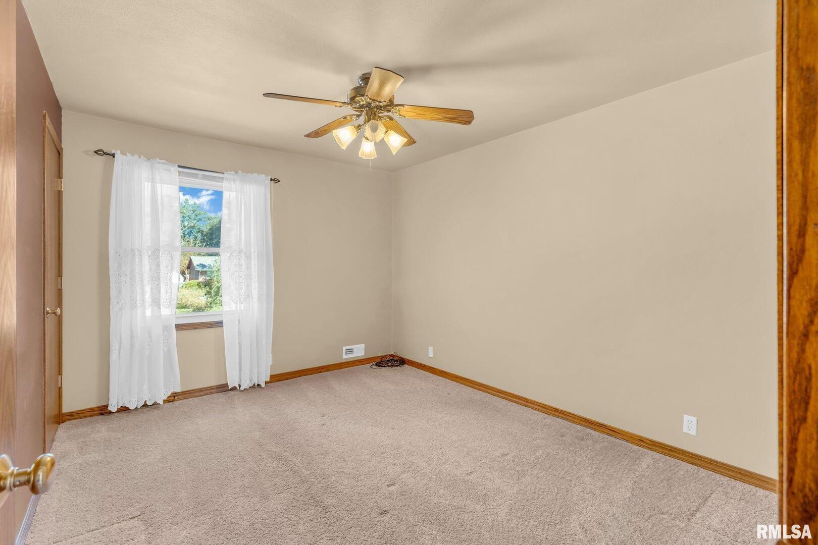 107 Hilltop Street Colona, IL 61241 - Photo 12 of 25 an empty room with windows and fan