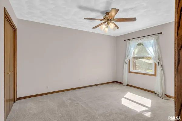an empty room with fan and windows