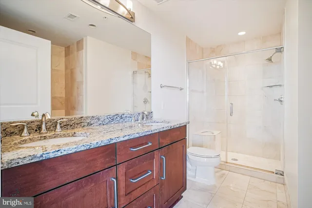 a bathroom with a granite countertop sink toilet and shower