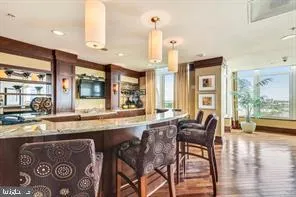 a open kitchen with granite countertop a stove a sink a dining table and chairs