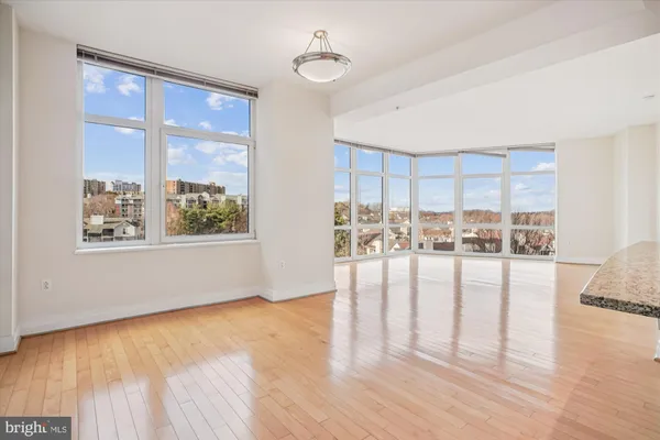 a view of empty room with wooden floor and floor to ceiling window