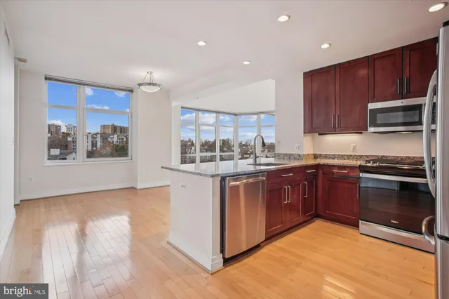 a kitchen with stainless steel appliances granite countertop a stove a sink and a microwave