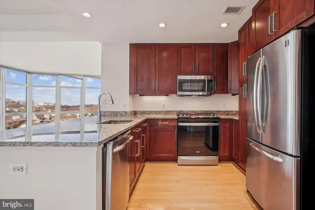 a kitchen with stainless steel appliances granite countertop a refrigerator stove and sink