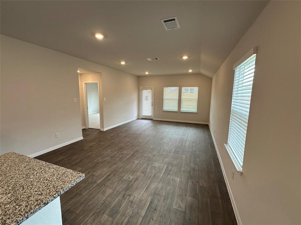 563 Evergreen Sumac Loop Kyle, TX 78640 - Photo 7 of 18 A well-lit living area with rich flooring offers a bright and welcoming atmosphere.