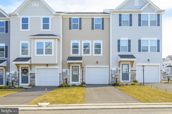 a view of a brick house with many windows and plants