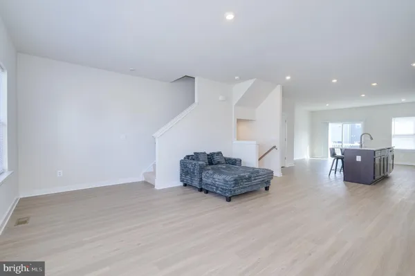 a living room with furniture and kitchen view