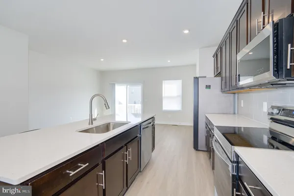 a kitchen with a sink a microwave a refrigerator and cabinets