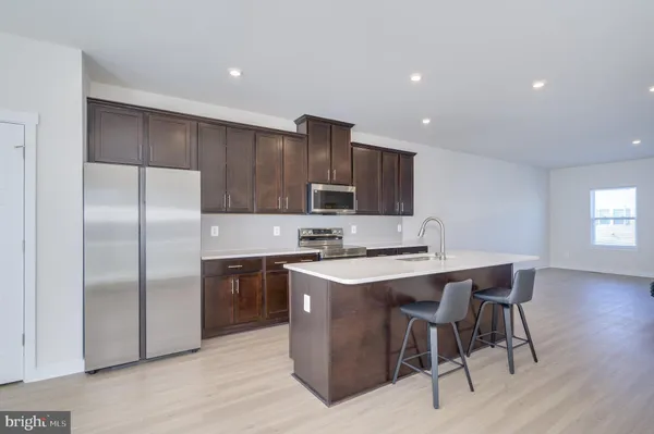 a kitchen with stainless steel appliances a sink stove and wooden cabinets
