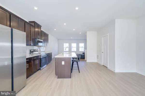 a kitchen with a stove a sink a refrigerator and cabinets