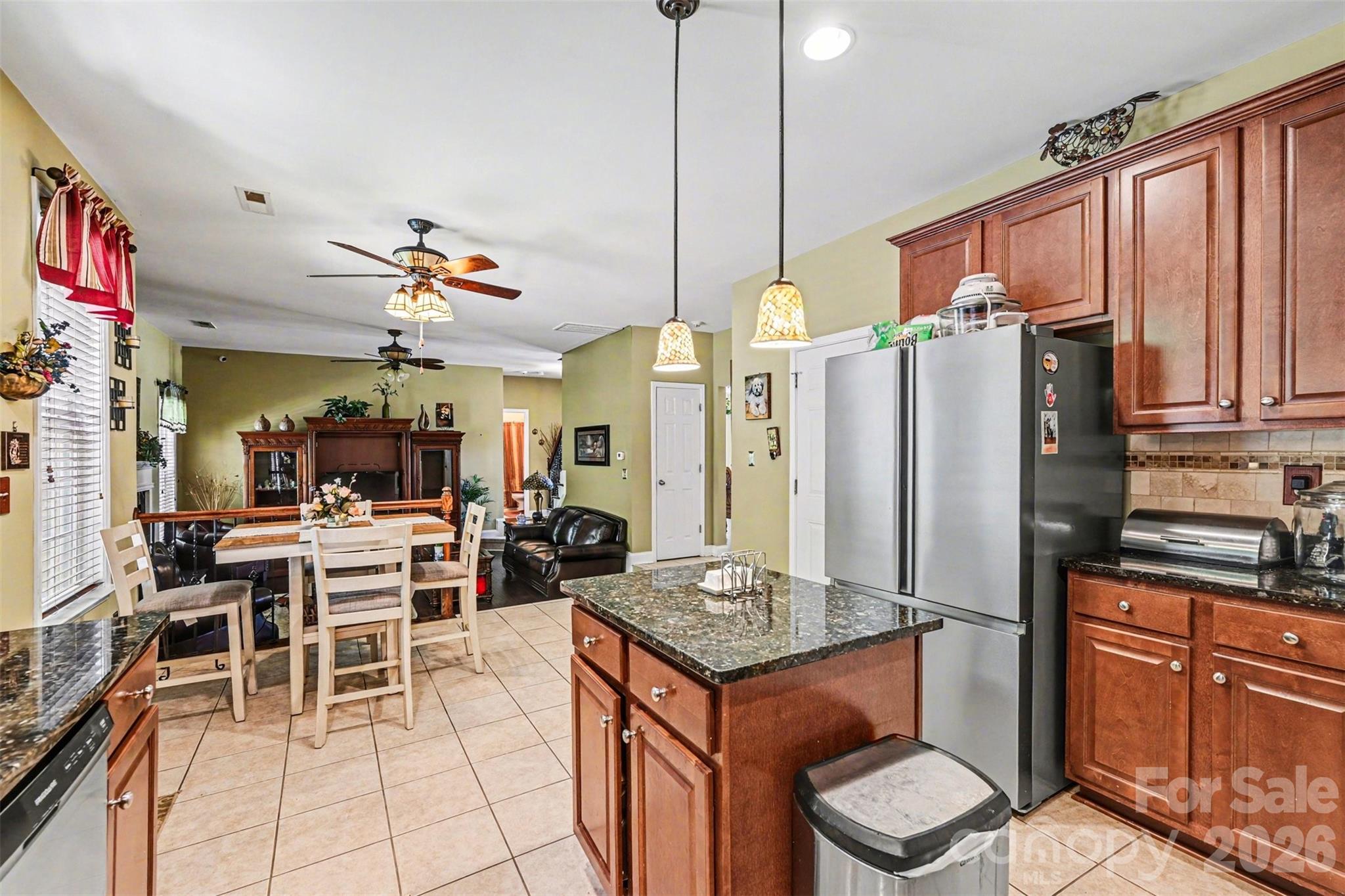 10812 Clark Street Davidson, NC 28036 - Photo 12 of 32 a kitchen with stainless steel appliances granite countertop a stove refrigerator a dining table and chairs with wooden floor