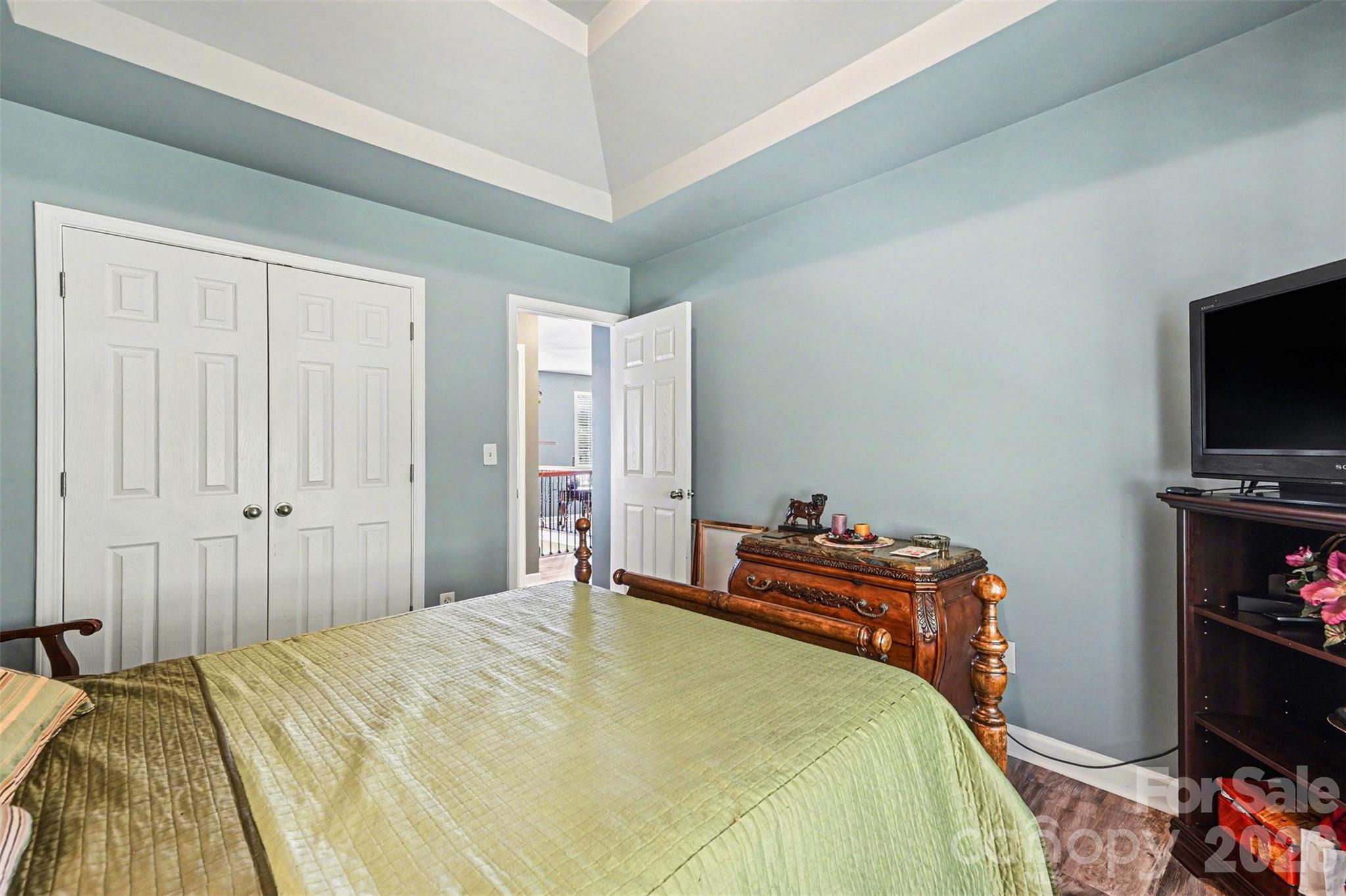 10812 Clark Street Davidson, NC 28036 - Photo 19 of 32 a bedroom with a bed and flat tv screen on the dresser