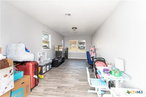 a bedroom with furniture a flat screen tv and a window