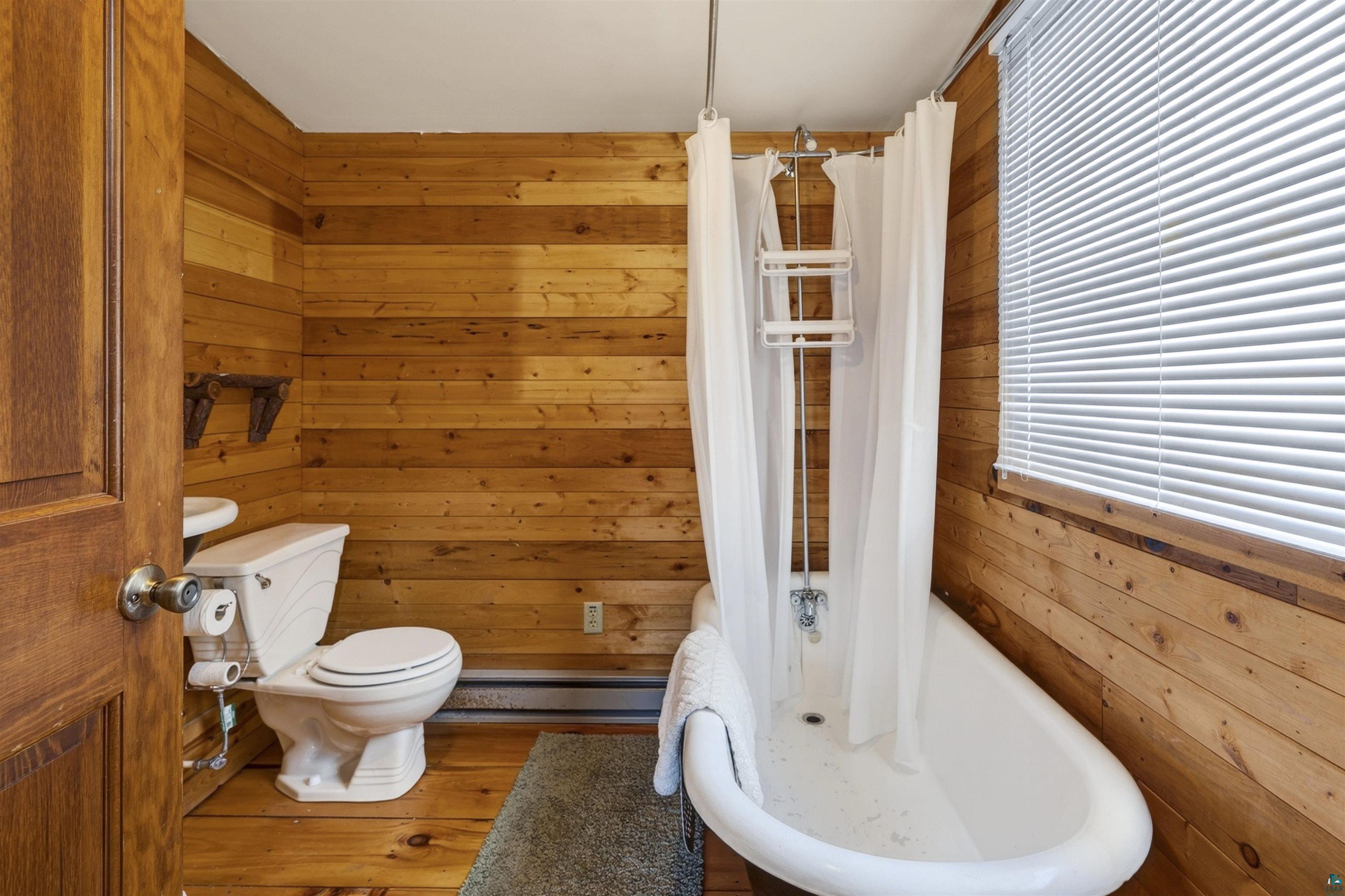 13885 Park Road Brule, WI 54820 - Photo 31 of 41 Bathroom featuring wood-paneled walls and wood-finish flooring