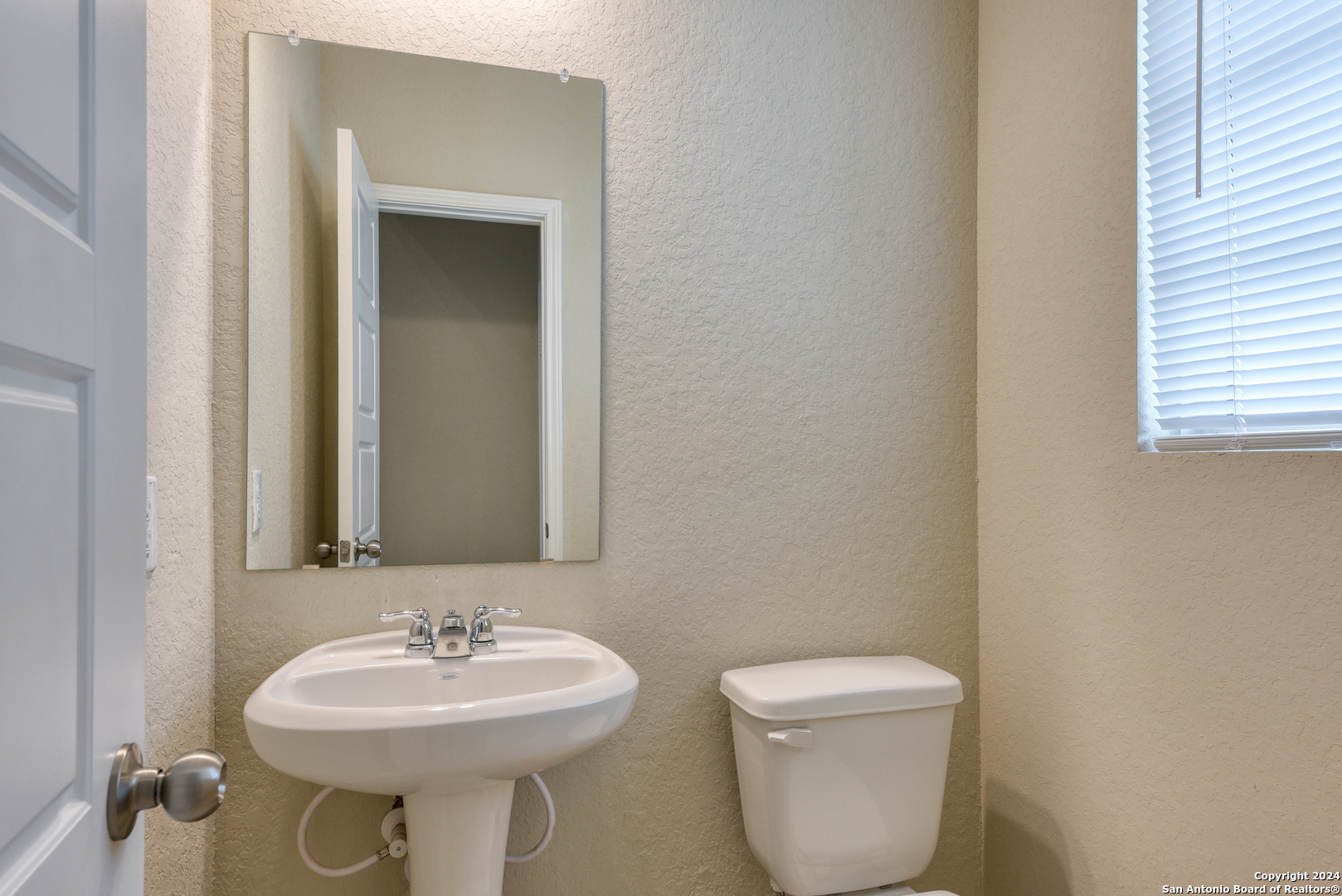 10546 Midsummer Meadow Converse, TX 78109 - Photo 3 of 18 a bathroom with a toilet sink and mirror