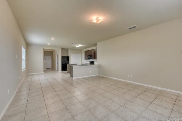 a view of kitchen with granite countertop cabinets and refrigerator