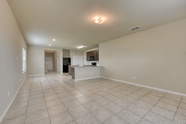 a view of kitchen with granite countertop cabinets and refrigerator