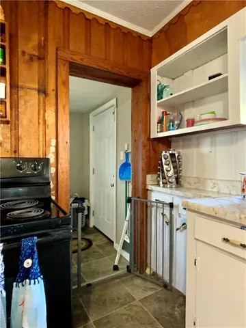 a kitchen with granite countertop a stove and cabinets