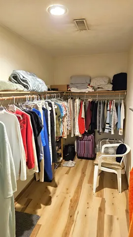 a view of walk in closet with clothes and shoes