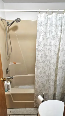 a bathroom with a toilet and a shower