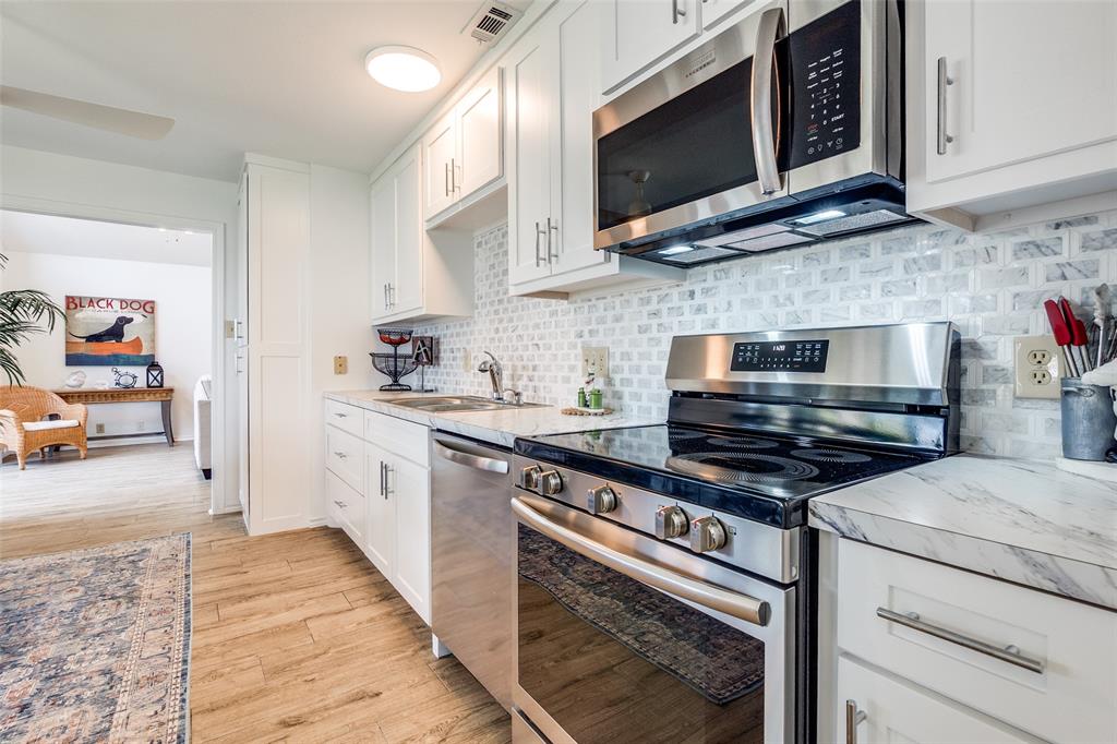 162 Aztec Drive Mabank, TX 75156 - Photo 11 of 30 a kitchen with stainless steel appliances a stove microwave and cabinets