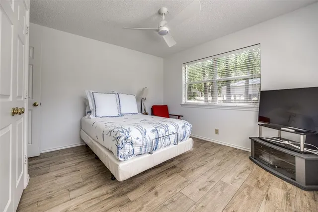a bedroom with a bed and a flat tv screen on a dresser
