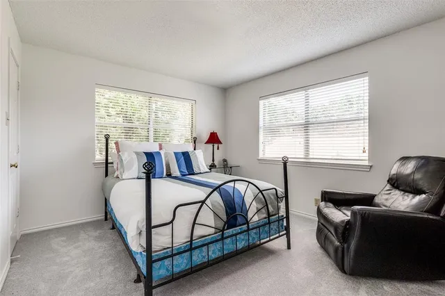 a bed room with a bed and two windows