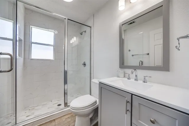 a bathroom with a sink a toilet and shower