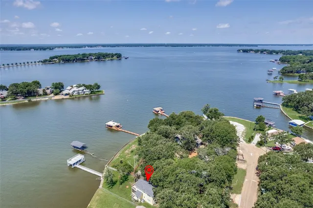 an aerial view of a house with a yard and lake view