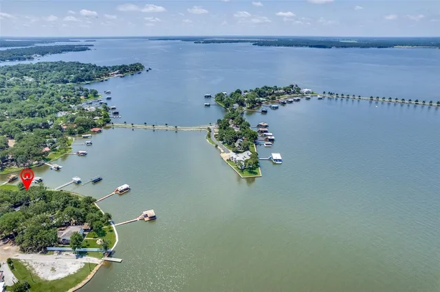 an aerial view of a house with a yard and lake view