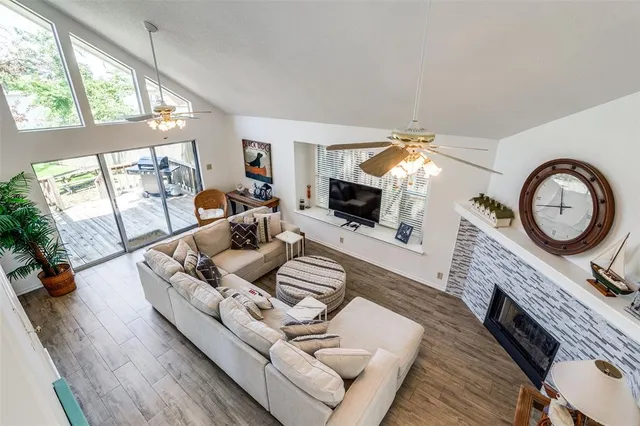 a living room with furniture a fireplace a flat screen tv and a large window