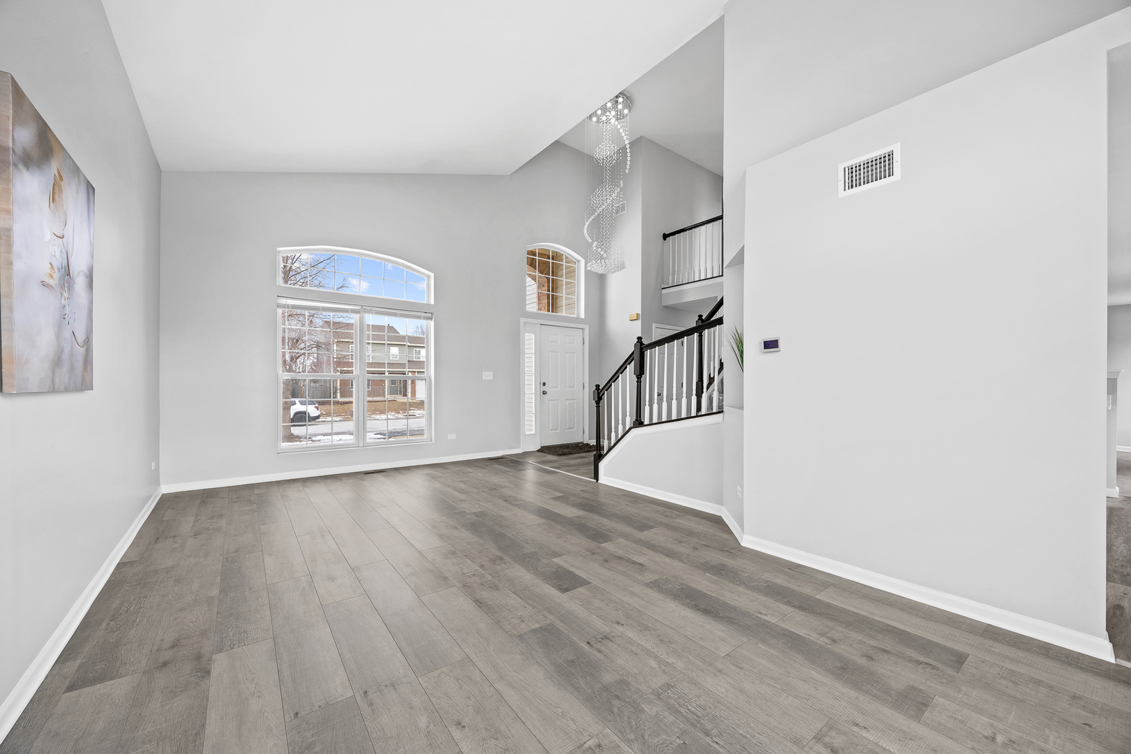 631 Kingsbrooke Crossing Bolingbrook, IL 60440 - Photo 7 of 40 a view of an empty room with wooden floor and a window