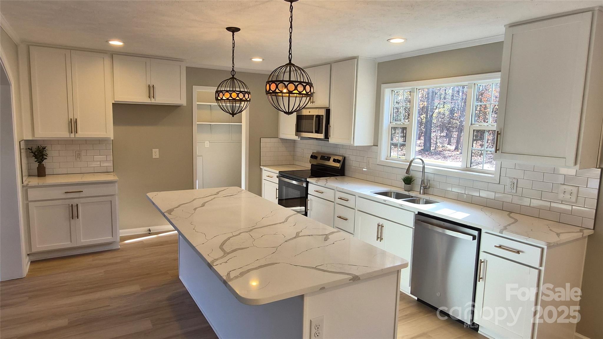 680 Tirzah Church Road Lancaster, SC 29720 - Photo 5 of 25 a kitchen with stainless steel appliances granite countertop a sink a stove a refrigerator and island with wooden floor