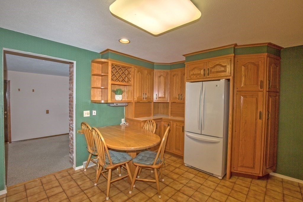 477 Wolf Swamp Road Longmeadow, MA 01106 - Photo 16 of 35 a kitchen with a refrigerator and table chair