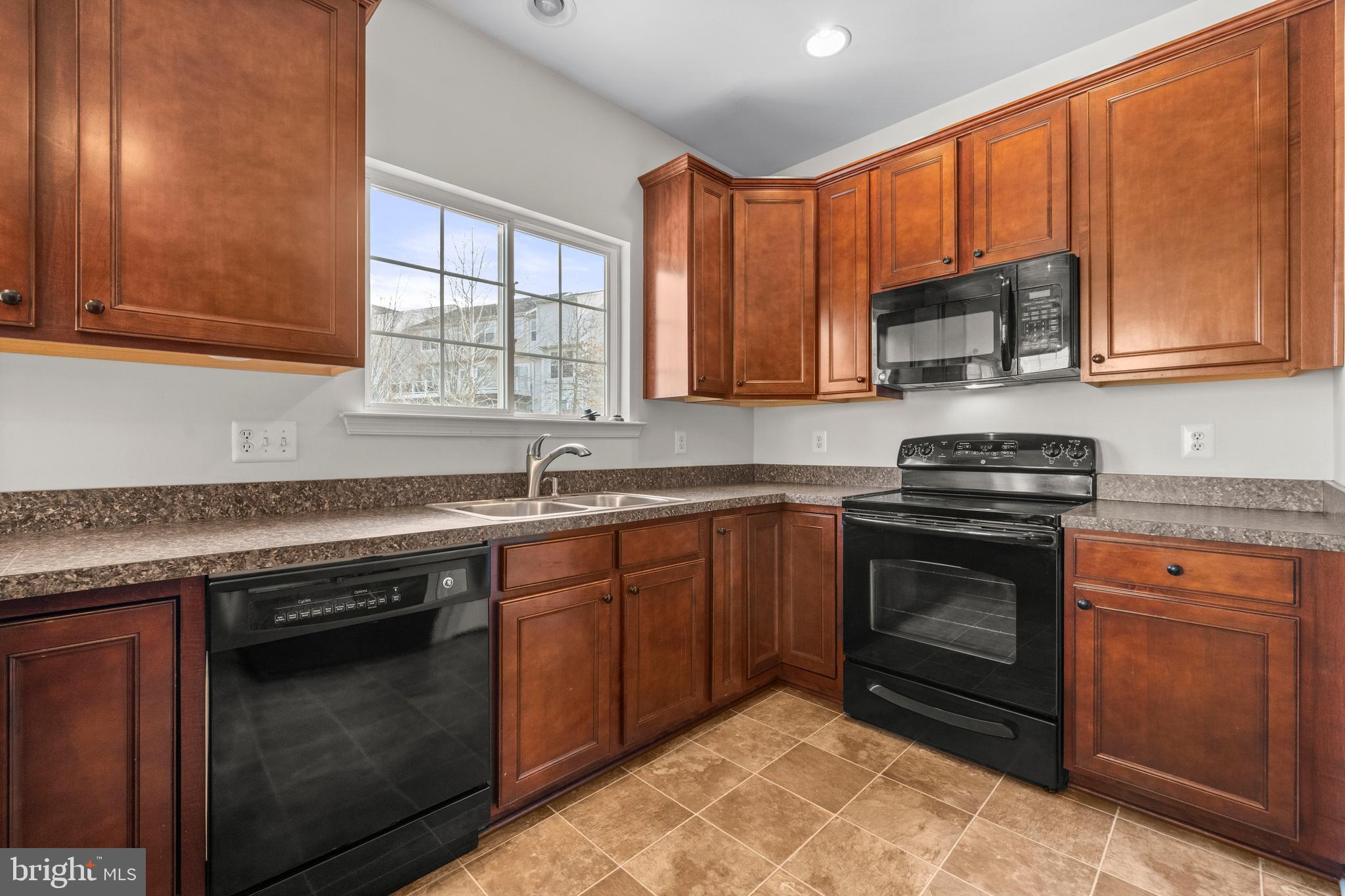 109 Gray Street Capitol Heights, MD 20743 - Photo 11 of 35 a kitchen with granite countertop a stove sink and cabinets