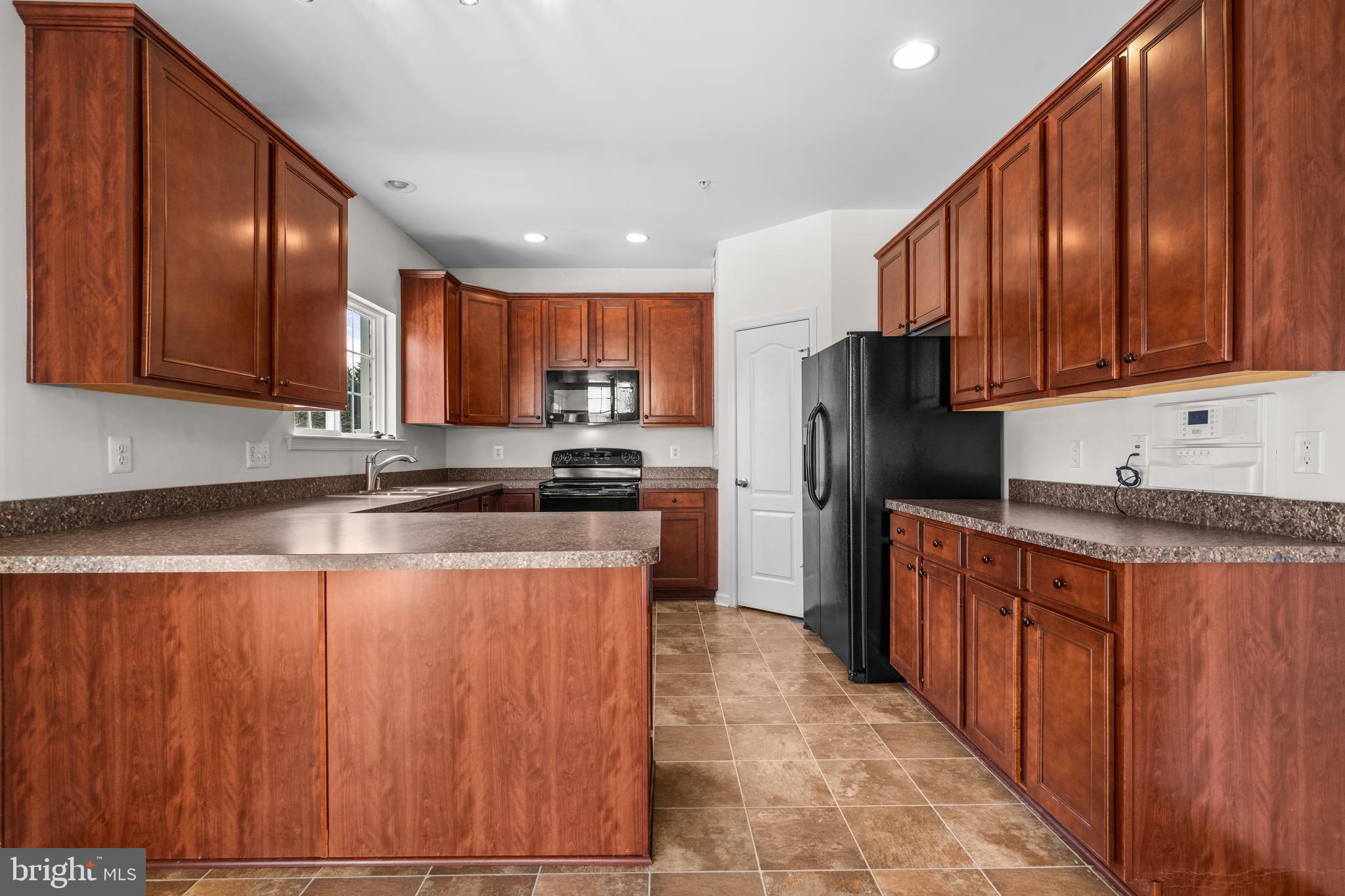 109 Gray Street Capitol Heights, MD 20743 - Photo 9 of 35 a kitchen with stainless steel appliances granite countertop wooden cabinets a refrigerator and a sink